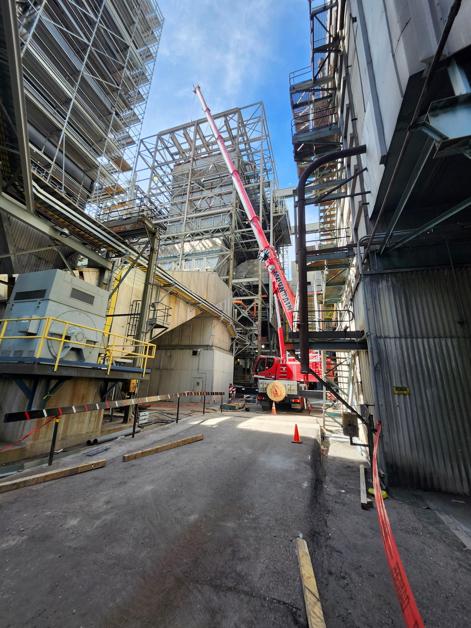 Industrial plant structure with crane and field work underway