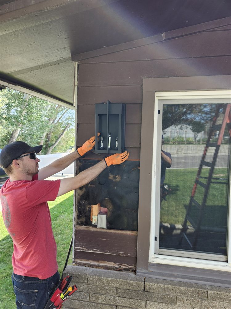 Technician performing exterior electrical repair work