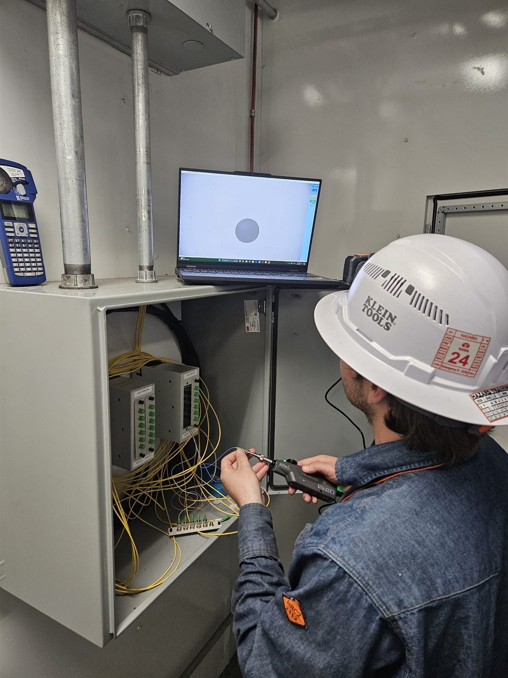Technician troubleshooting fiber and controls wiring